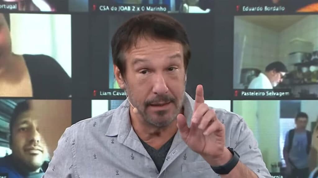 Imagem do apresentador Emílio Surita apontando o dedo para cima no estúdio do programa Pânico