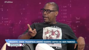 Imagem do ator André Ramiro sentado em uma poltrona no cenário do programa Foi Mau, da RedeTV!