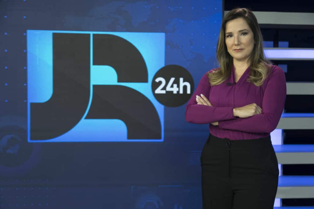 Imagem da jornalista Adriana Perroni no cenário do Jornal da Record