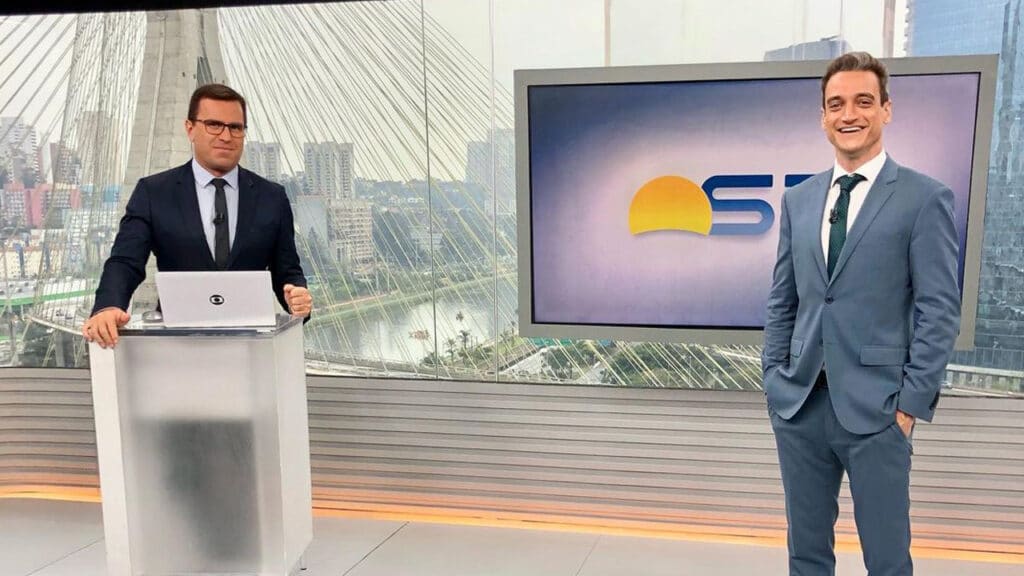 Imagem com foto dos jornalistas Rodrigo Bocardi e Tiago Scheuer no glass studio da Globo em São Paulo