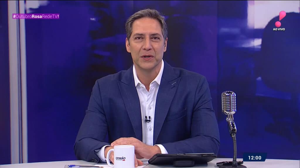 Imagem do apresentador Luís Ernesto Lacombe na bancada do Opinião no Ar da RedeTV!