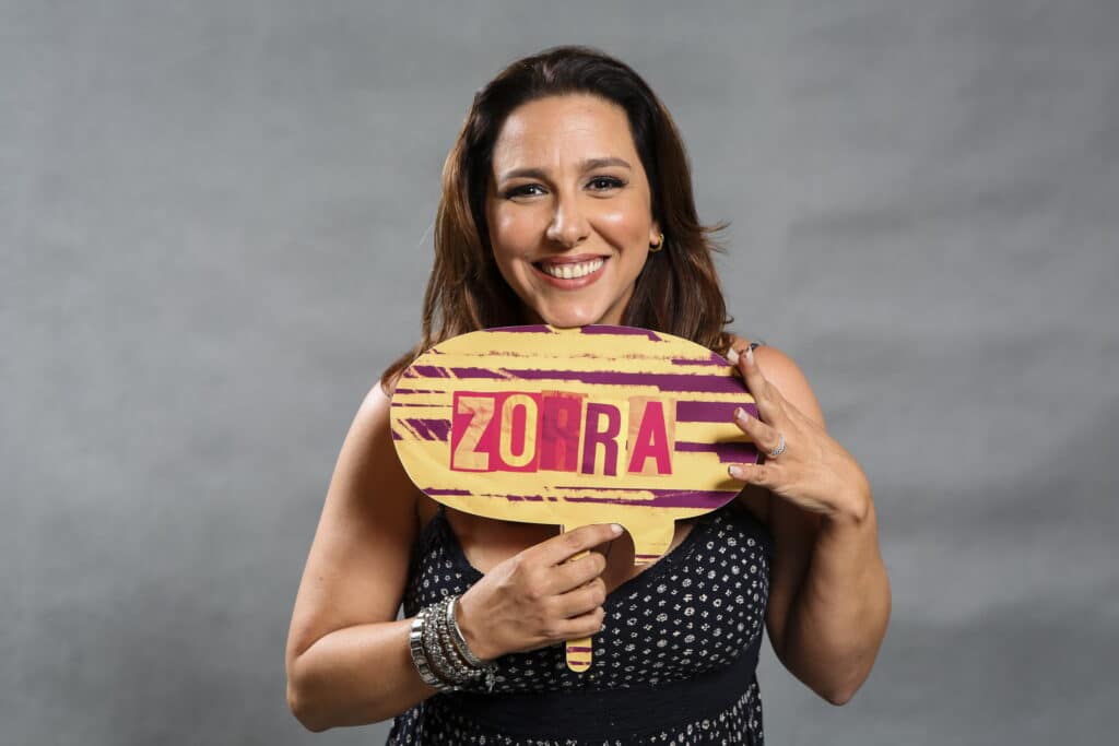 Imagem da atriz Renata Castro Barbosa segurando uma plaquinha com o nome do Zorra