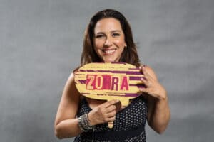 Imagem da atriz Renata Castro Barbosa segurando uma plaquinha com o nome do Zorra