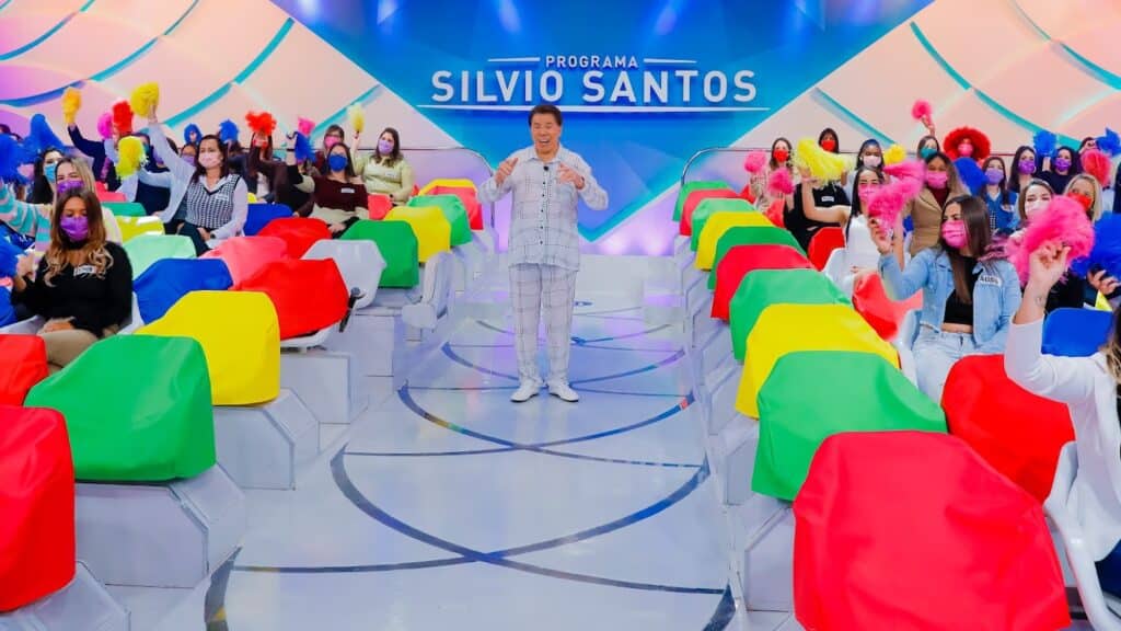 Imagem com foto do apresentador Silvio Santos apresentando seu programa vestido de pijama