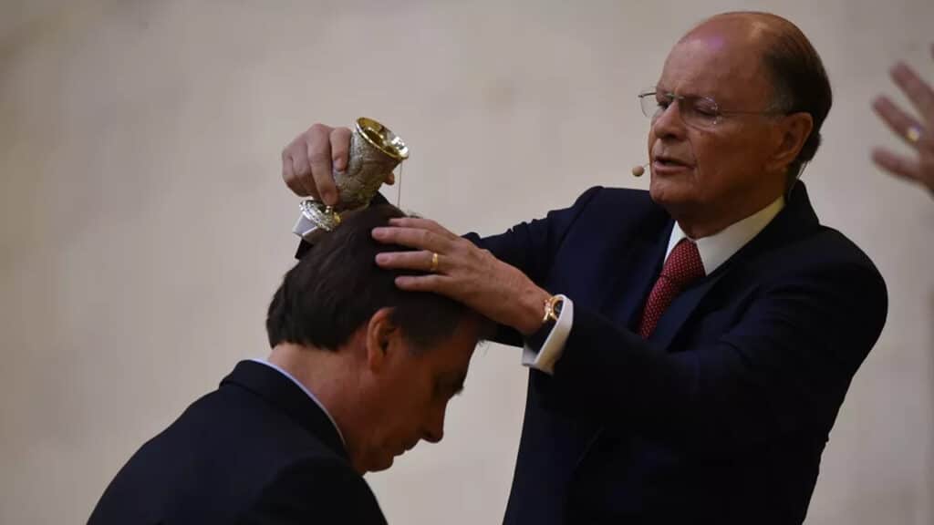 Imagem do presidente Jair Bolsonaro sendo abençoado pelo bispo Edir Macedo