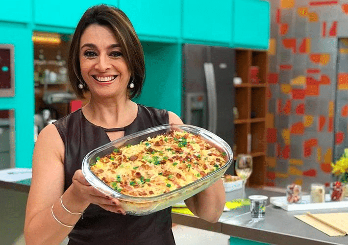 Foto da apresentadora Catia Fonseca segurando um prato de comida