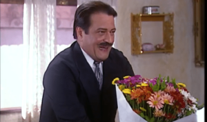 Batista tenta enganar Joana com flores em O Cravo e a Rosa