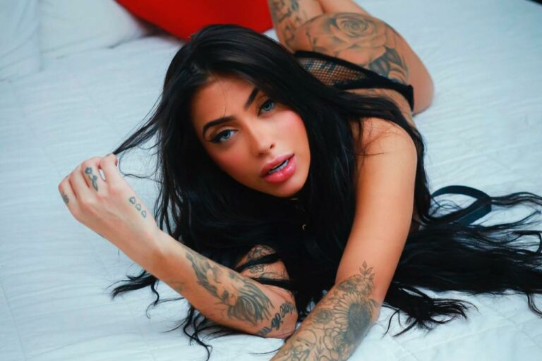 Foto da funkeira MC Mirella deitada em uma cama