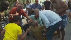 Imagem com foto do cinegrafista Rogério de Paula sendo socorrido após ataque de apoiadores de Roberto Jefferson