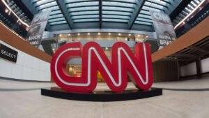 Imagem com foto do logotipo da CNN Brasil na entrada do prédio da emissora