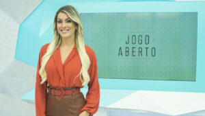 Imagem com foto da apresentadora Renata Fan no cenário do Jogo Aberto