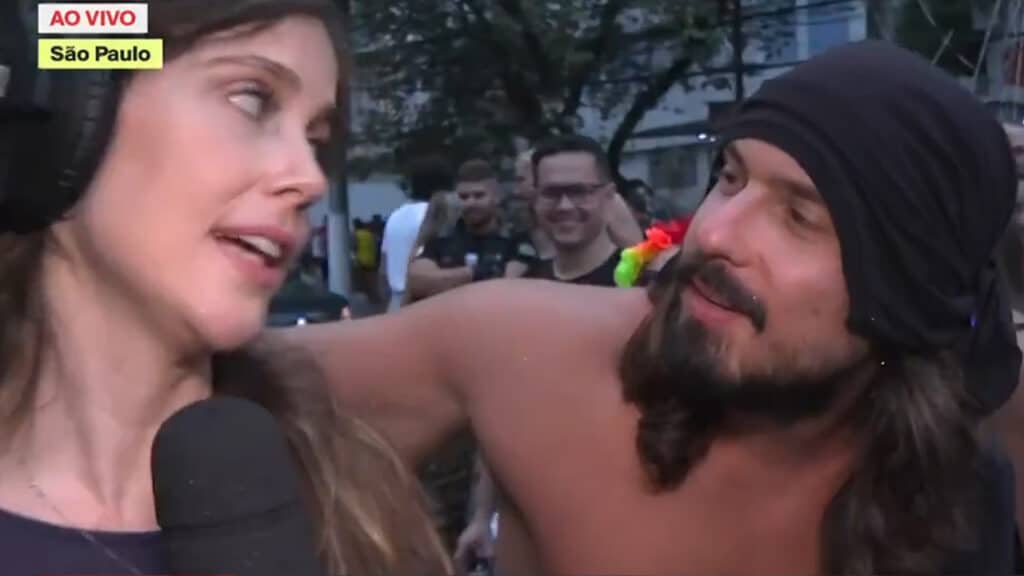 Imagem com foto do momento em que a repórter Júlia Zaremba é surpreendida por homem com pedido de beijo