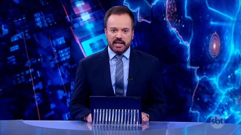 Foto do apresentador Marcelo Torres na bancada do telejornal SBT Brasil