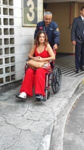 Fátima Bernardes de cadeira de rodas na portaria da Globo