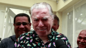 Silvio Santos sorridente durante festa de aniversário na porta da casa dele