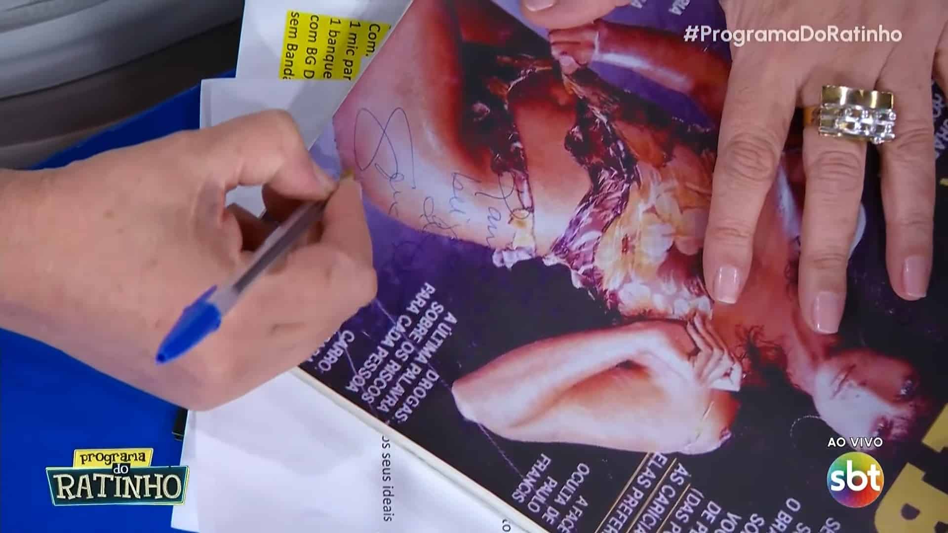 Foto de Sônia Lima autografando sua Playboy durante o Programa do Ratinho