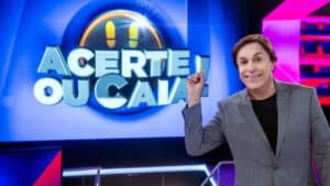 Tom Cavalcante apontando o dedo indicador para o logotipo do Acerte ou Caia!, novo game da Record