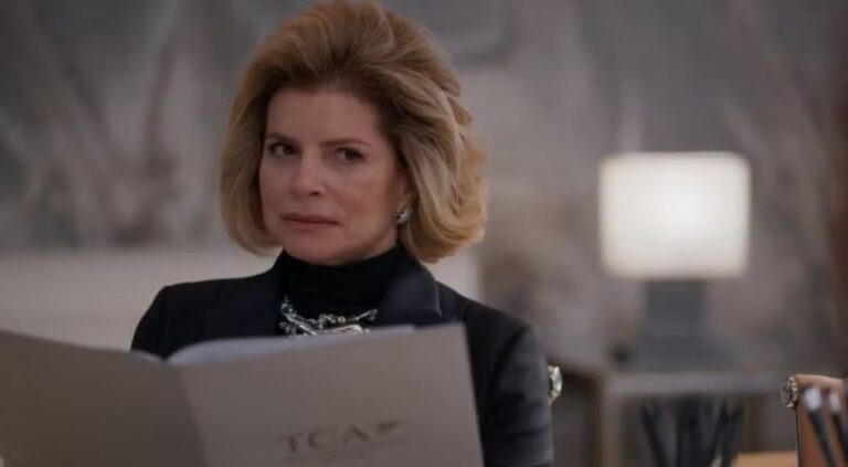 Na imagem, a personagem Odete Roitman aparece em cena do remake da novela Vale Tudo (2025), exibindo um olhar desconfiado e expressão firme. Sentada em um ambiente elegante e moderno, ela segura uma pasta com a sigla "TCA", sinalizando um momento de reunião ou decisão empresarial.