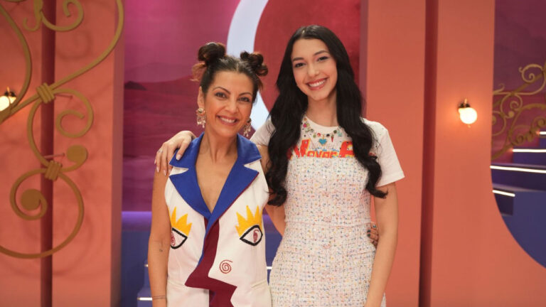 Thalita Rebouças e Luluca sorrindo lado a lado no cenário colorido do reality Partiu 15 da Globo