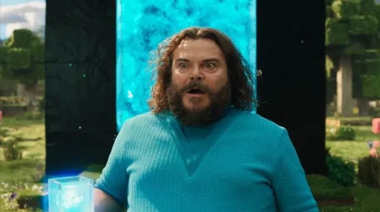 Jack Black em cena de Um Filme Minecraft, caracterizado como Steve, diante de um portal brilhante em tons de azul. Com expressão de surpresa e segurando um cubo luminoso, o ator aparece em um cenário inspirado no universo do jogo, cercado por elementos pixelados e vegetação estilizada.