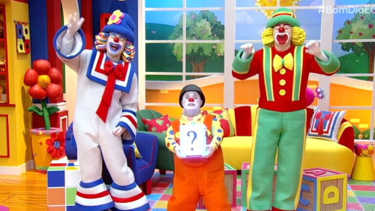 Patati, Patatá e um terceiro palhaço com nanismo no cenário colorido do programa infantil Bom dia & Cia do SBT