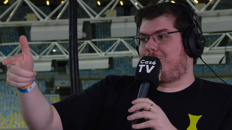 Casimiro Miguel com microfone da CazéTV durante transmissão em estádio de futebol