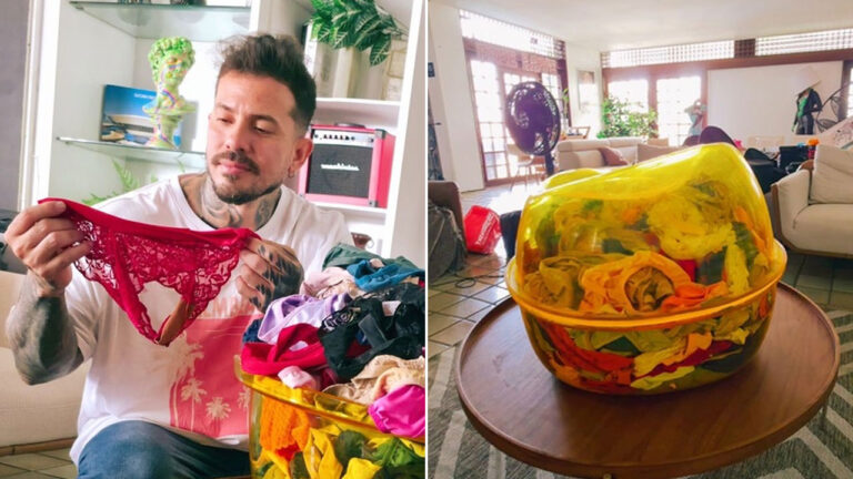 Arthur O Urso sentado em sala segurando calcinha vermelha rendada ao lado de bacia cheia de peças íntimas coloridas