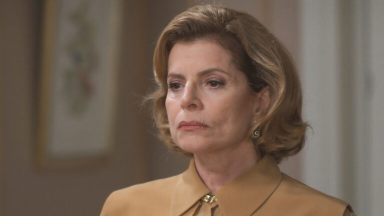 Odete Roitman (Débora Bloch) com expressão séria usando blusa bege em cena da novela Vale Tudo