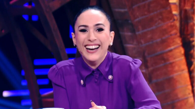 Tatá Werneck sorrindo com camisa roxa durante apresentação do Lady Night no cenário iluminado do programa