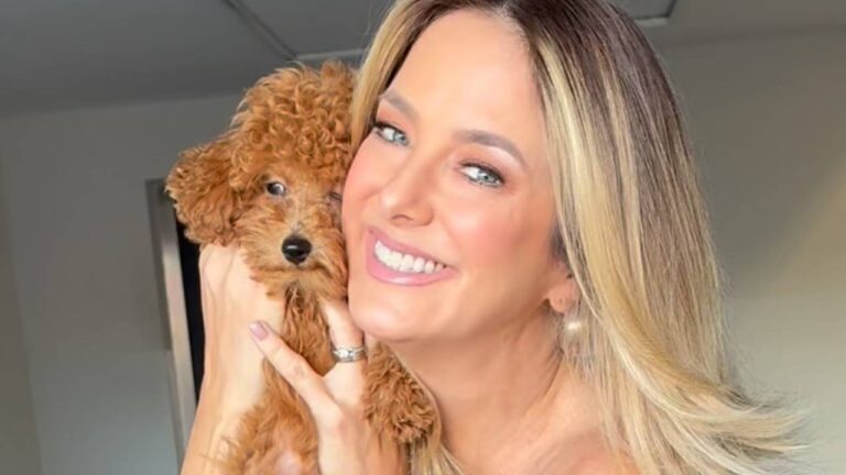 Ticiane Pinheiro sorri segurando filhote de cachorro marrom de pelo cacheado junto ao rosto