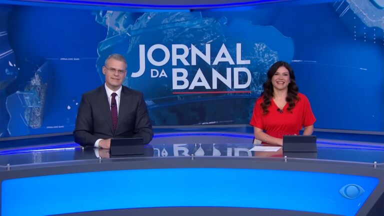 Foto de Eduardo Oinegue e Thais Dias na bancada do Jornal da Band