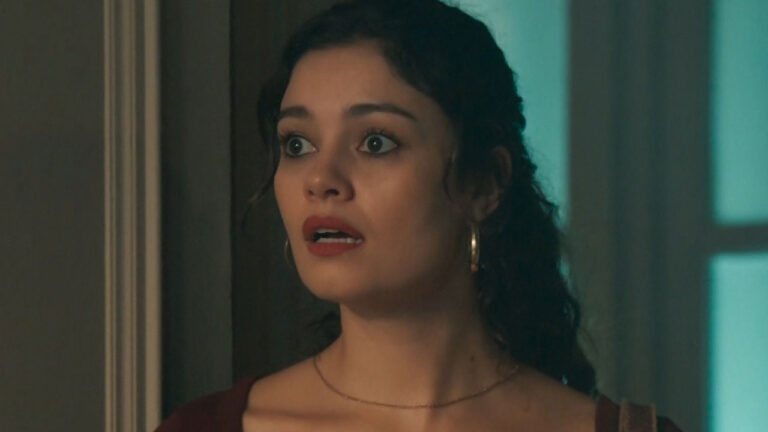 Gerluce (Sophie Charlotte) com blusa vinho e brincos de argola olha com expressão de choque e olhos arregalados em cena de Três Graças