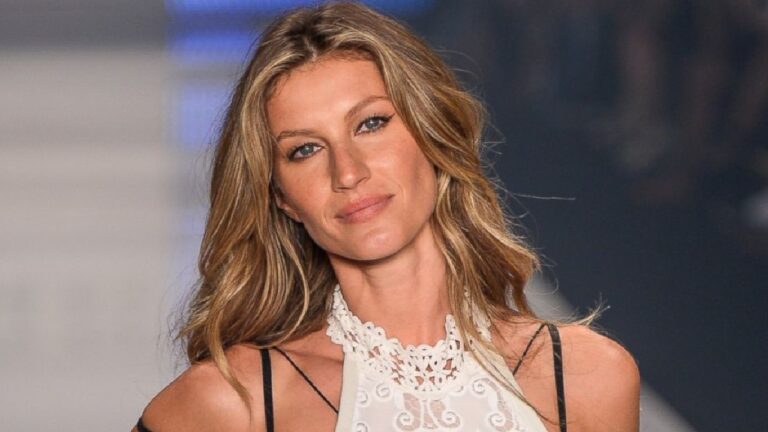 Gisele Bündchen desfilando com vestido branco em passarela de evento de moda