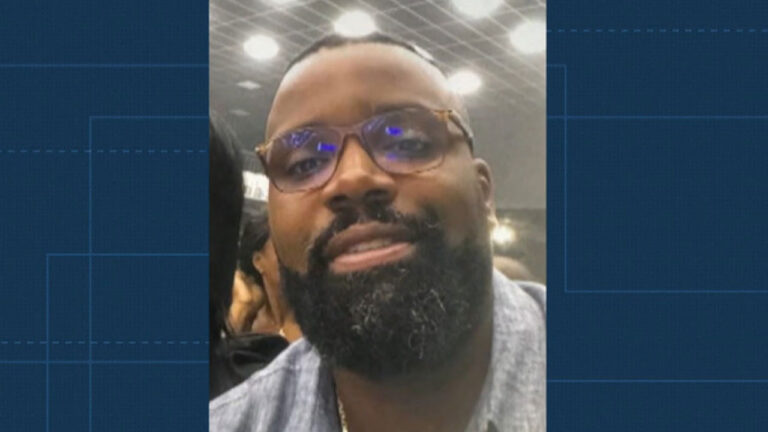 Júlio César de Oliveira Silva Rodrigues, homem negro de barba e óculos de grau posando em close-up