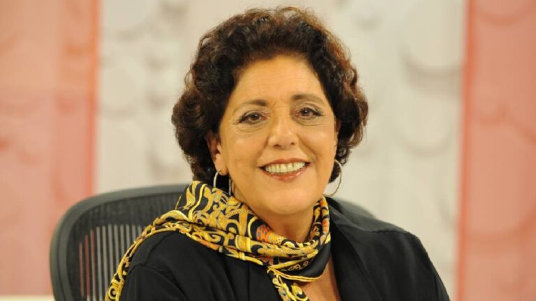 Leda Nagle sorrindo durante gravação de programa em estúdio com fundo claro