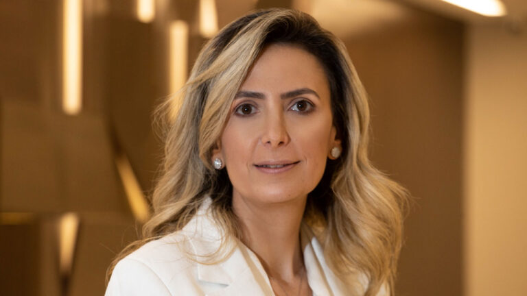 A médica Ludhmila Hajjar com cabelo loiro e blazer branco olha diretamente para a câmera com expressão serena em foto de perfil