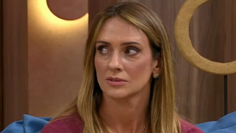 Monique Arruda com expressão séria durante participação em programa de TV em estúdio com iluminação quente