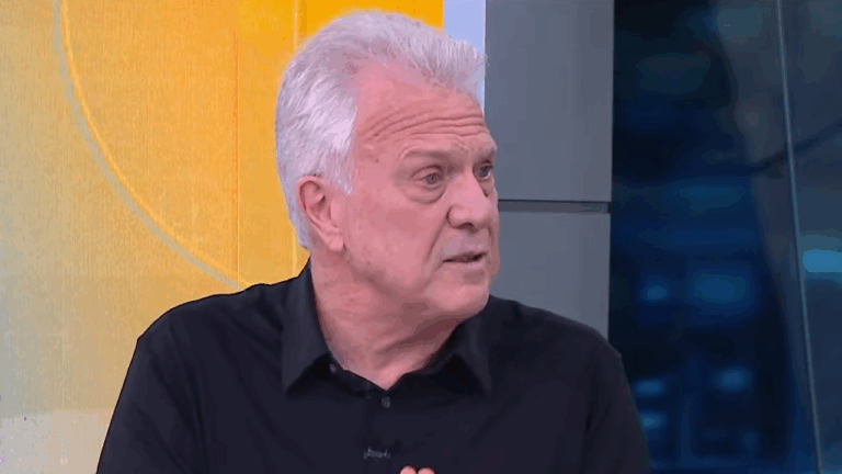 Pedro Bial fala durante participação em programa de TV com cenário colorido ao fundo