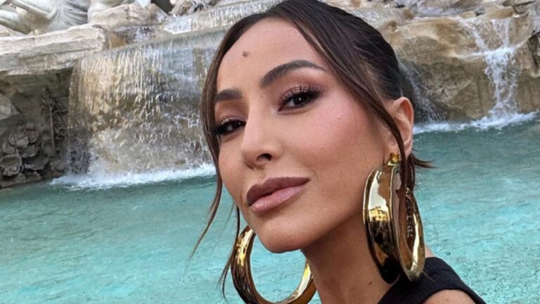 Sabrina Sato posa para selfie usando brincos dourados grandes diante da Fontana di Trevi em Roma