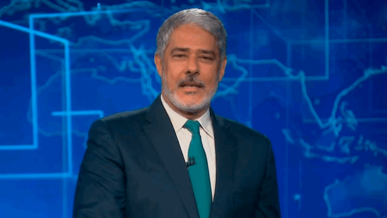William Bonner apresenta o Jornal Nacional em estúdio com mapa azul ao fundo