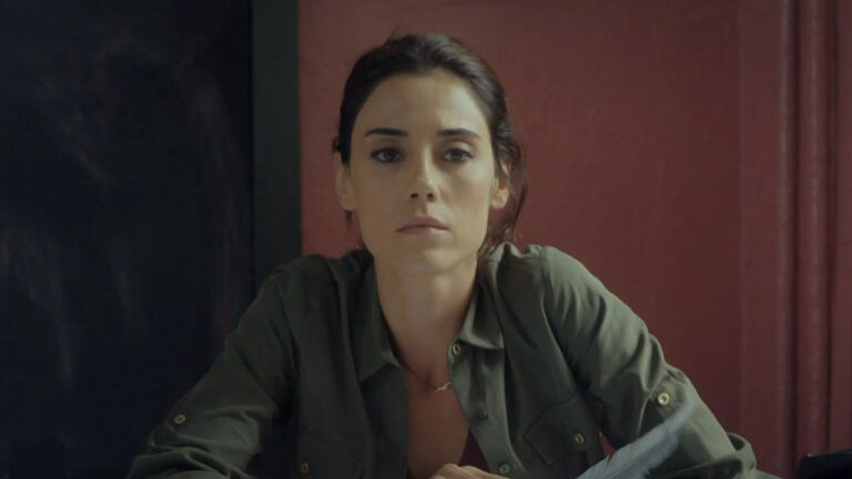 Zeynep Gunes, interpretada por Cansu Dere, sentada com expressão séria usando camisa verde em cena da novela Mãe