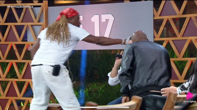 Participante de bandana vermelha avança para golpear outro homem durante dinâmica da formação da Roça em A Fazenda