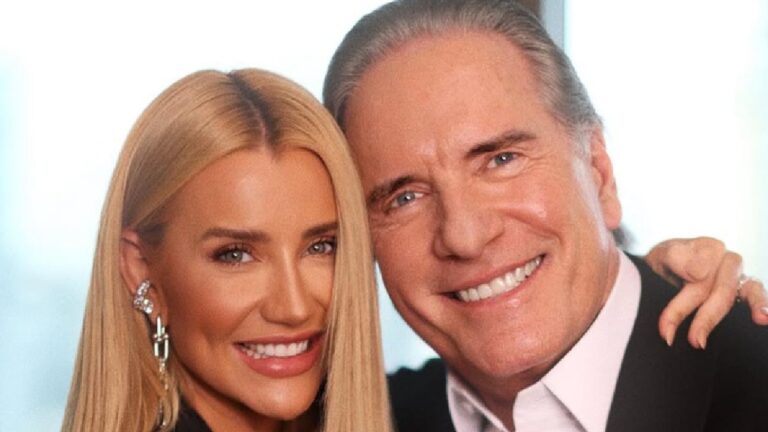 Homem e mulher sorrindo lado a lado em ambiente iluminado com fundo desfocado