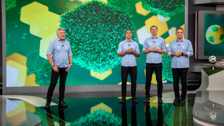 Cléber Machado, Dodô, Sálvio Spinola e Maurício Noriega em pé, usando camisas azuis no estúdio de futebol da Record