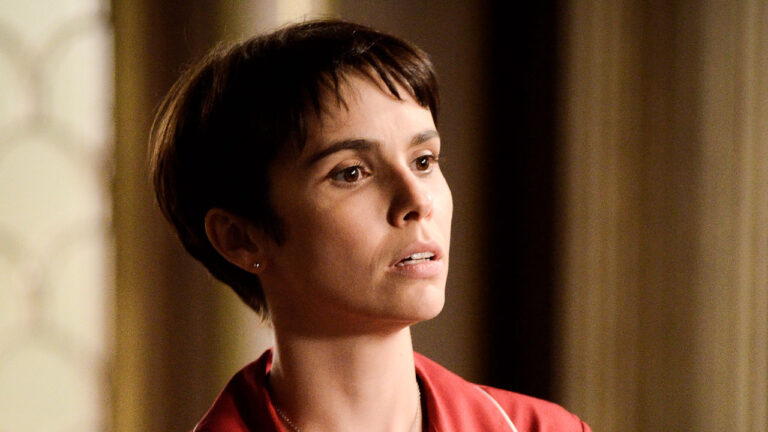 Débora Falabella como Nina com cabelo curto escuro e franja usando pijama vermelho em cena da novela Avenida Brasil