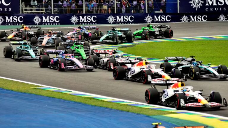 Carros de Fórmula 1 fazem uma curva disputada no autódromo de Interlagos, durante o Grande Prêmio de São Paulo. Os monopostos de diferentes equipes aparecem próximos uns dos outros