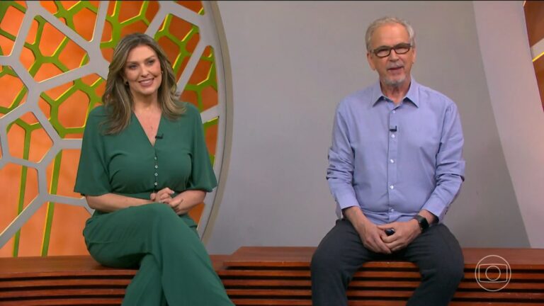 Cristina Vieira e Nélson Araújo sentados em estúdio colorido com tons de laranja e verde, do programa Globo Rural, conversam sorridentes diante de um painel decorativo geométrico