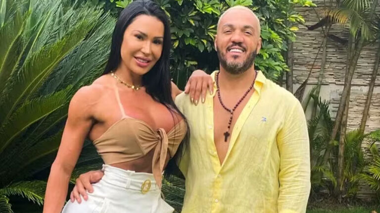 Gracyanne Barbosa com top bege e o cantor Belo de camisa amarela, ambos sorrindo em um jardim