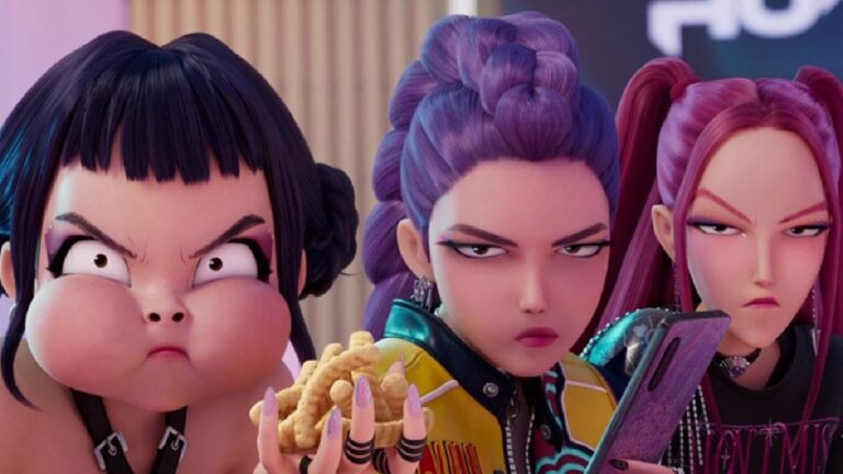 Cena de animação mostra três garotas com expressões irritadas; uma segura batatas fritas, outra um celular, e todas têm penteados e roupas coloridas e modernas