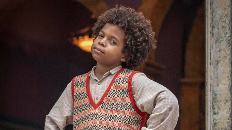 O ator mirim Levi Asaf como Marcelino, com suéter em estampa geométrica e camisa clara, em pose confiante na novela Amor Perfeito